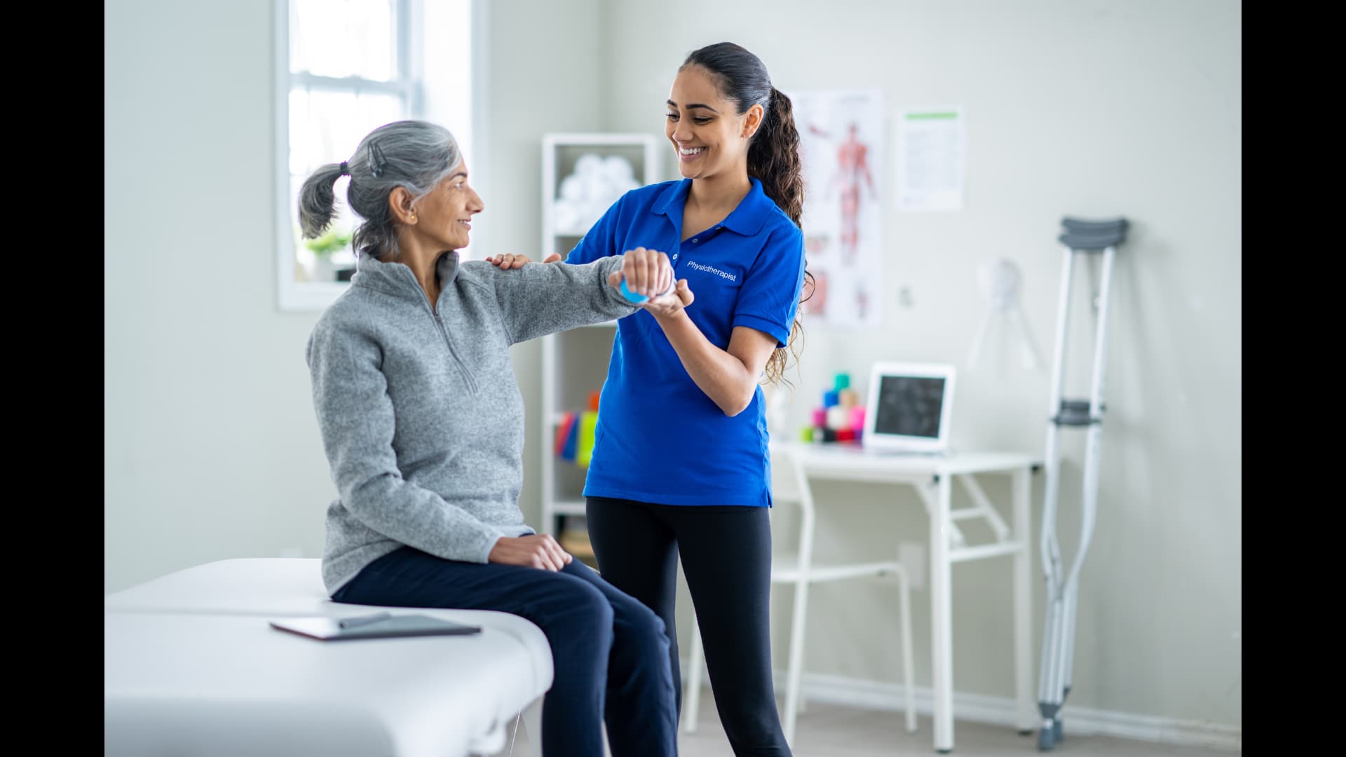 Fysioterapeut som arbeider med pasient i moderne fysioterapiklinikk - illustrerer hvordan PhysioNote gir fysioterapeuter mer tid til det som betyr mest